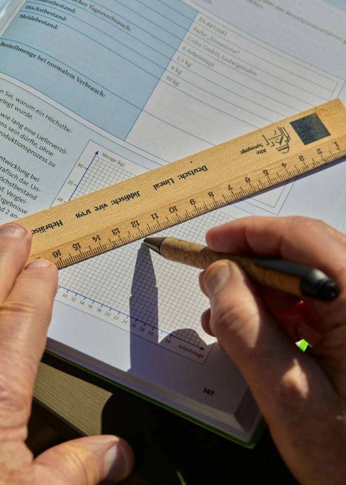Someone is drawing a graph with a ruler and pen